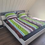 Bedroom with double bed, nightstand, and window