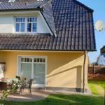 Haus mit Terrasse, Garten und Dachfenstern. Satellitenschüssel an der Wand.