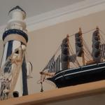 Modell eines Leuchtturms und eines Segelschiffs auf einem Regal.