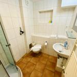 Badezimmer mit Dusche, Toilette und Waschbecken.