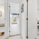 Bright rooms with white walls and wooden floors. Corridor to sleeping and working areas.