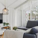 Living room with sofa, TV, and large windows.