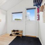 Entrance with washing machine, shoe rack, and door with window.