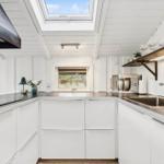Kitchen with white cabinets, stainless steel sink, and skylight.