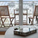 Round table with puzzle, mug, and candle holders before balcony with wooden chairs.