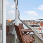 Terrace with wooden chairs and view of red roofs.