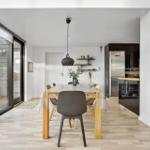 Dining room with table, chairs, and view of the kitchen.