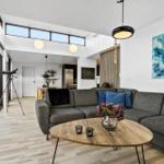 Living room with gray sofa, wooden table, and blue wall art.