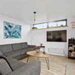 Living room with sofa, coffee table, and TV mounted on the wall.