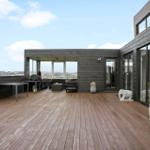 Large wooden terrace with seating and elephant statues. View of the landscape.