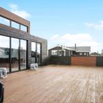 Deck with wooden floor, glass walls, and stone elephant statues. View of neighboring houses.