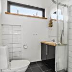 Bathroom with shower, sink and toilet. Window with view of lighthouse.