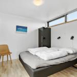 Bedroom with bed, wardrobe, and TV mounted on the wall.