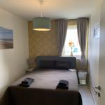 Schlafzimmer mit Bett, Fenster und Wandbild.