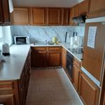 Küche mit Mikrowelle, Cerankochfel, Kühlschrank mit Grierfach und  Backofen.