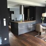 Moderne Küche mit Kücheninsel und Essbereich.