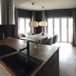 Küche mit Essbereich, Holzboden und großen Fenstern.