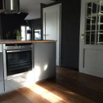 Moderne Küche mit Edelstahlherd und Holzboden.