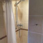 Dusche mit Duschbrause und weißen Vorhängen