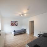 Zwei Betten, Fernseher und Wandbild im Schlafzimmer.