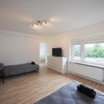 Zwei Betten, Fernseher und Fenster mit Blick auf Grün.