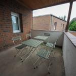 Terrasse mit Tisch und Stühlen, Blick auf Nachbarhäuser und Grünflächen.