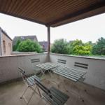 Terrasse mit Tisch und Stühlen unter Dach