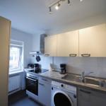 Küche mit Spüle, Kochfeld und Waschmaschine