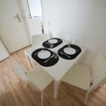 Essbereich mit weißem Tisch und vier Stühlen, gedeckt für vier Personen.