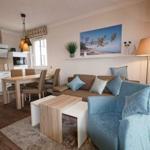 Wohn- und Essbereich mit Sofa, Sitzgelegenheit und Küchenzeile.