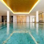 Innere Poolanlage mit goldfarbenem Deckenlicht und Liegestühlen.