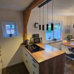 Küche mit Essbereich und Wohnzimmer im Hintergrund.