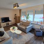 Wohnzimmer mit Sofa, Fernseher und Fenster