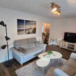 Wohnzimmer mit Sofa, Couchtisch und Fernseher.