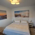Schlafzimmer mit Doppelbett, zwei Nachttischen und Wandbildern