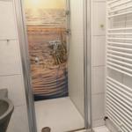 Duschkabine mit Strandmotivwand, Handbrause und Heizkörper