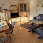 Wohn- und Essbereich mit Sofa, Esstisch und TV-Möbel.