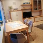 Essbereich mit Tisch, Stühlen und Fernseher im Wohnbereich.