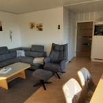 Wohn- und Essbereich mit Sofa, Esstisch und Küchenzeile.