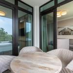 Essbereich mit Tisch und Stühlen, Blick auf Balkon und Wohnzimmer.