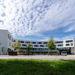 Moderne Wohnanlage mit großzügigem Eingangsbereich und gepflegtem Grünflächenbereich.