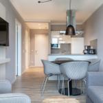 Wohn- und Essbereich mit Küchenzeile und TV.