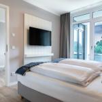 Schlafzimmer mit Doppelbett, TV und Balkonzugang.