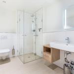 Moderne Badewanne mit Dusche, Waschbecken und Spiegel