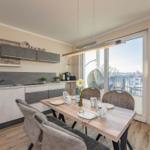 Küche mit Esstisch und Blick auf Balkon mit Hängesessel.