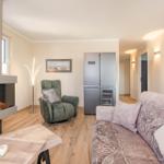 Wohnbereich mit Kamin, Sofa und Kühlschrank.