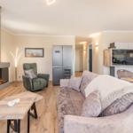 Wohn- und Essbereich mit Kamin, Sofa und Esstisch.