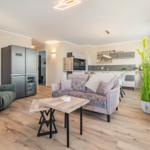 Wohn- und Küchenbereich mit Kamin, Sofa und Küchenzeile.