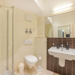 Badezimmer mit Dusche, Toilette und Waschbecken.