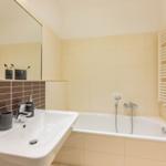 Badezimmer mit Badewanne, Waschbecken und Spiegel